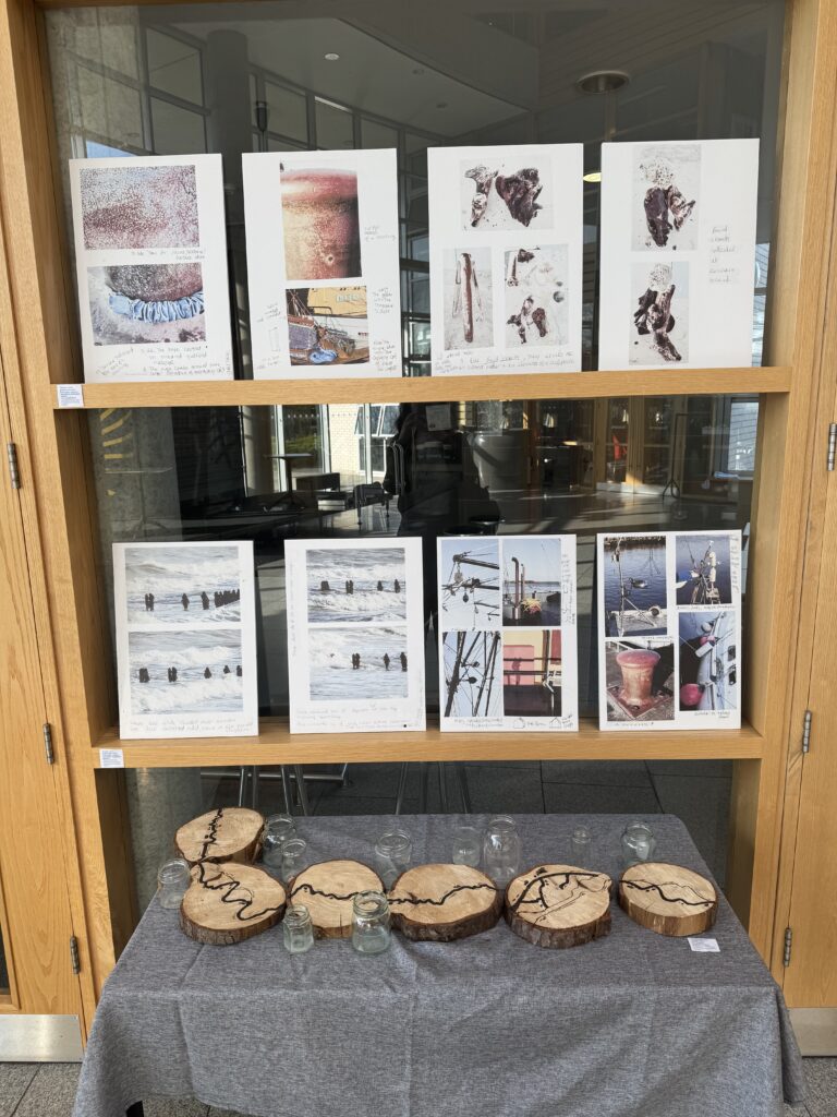 Photograph of art exhibiton 8 vertical picture and a disply of wood carvings