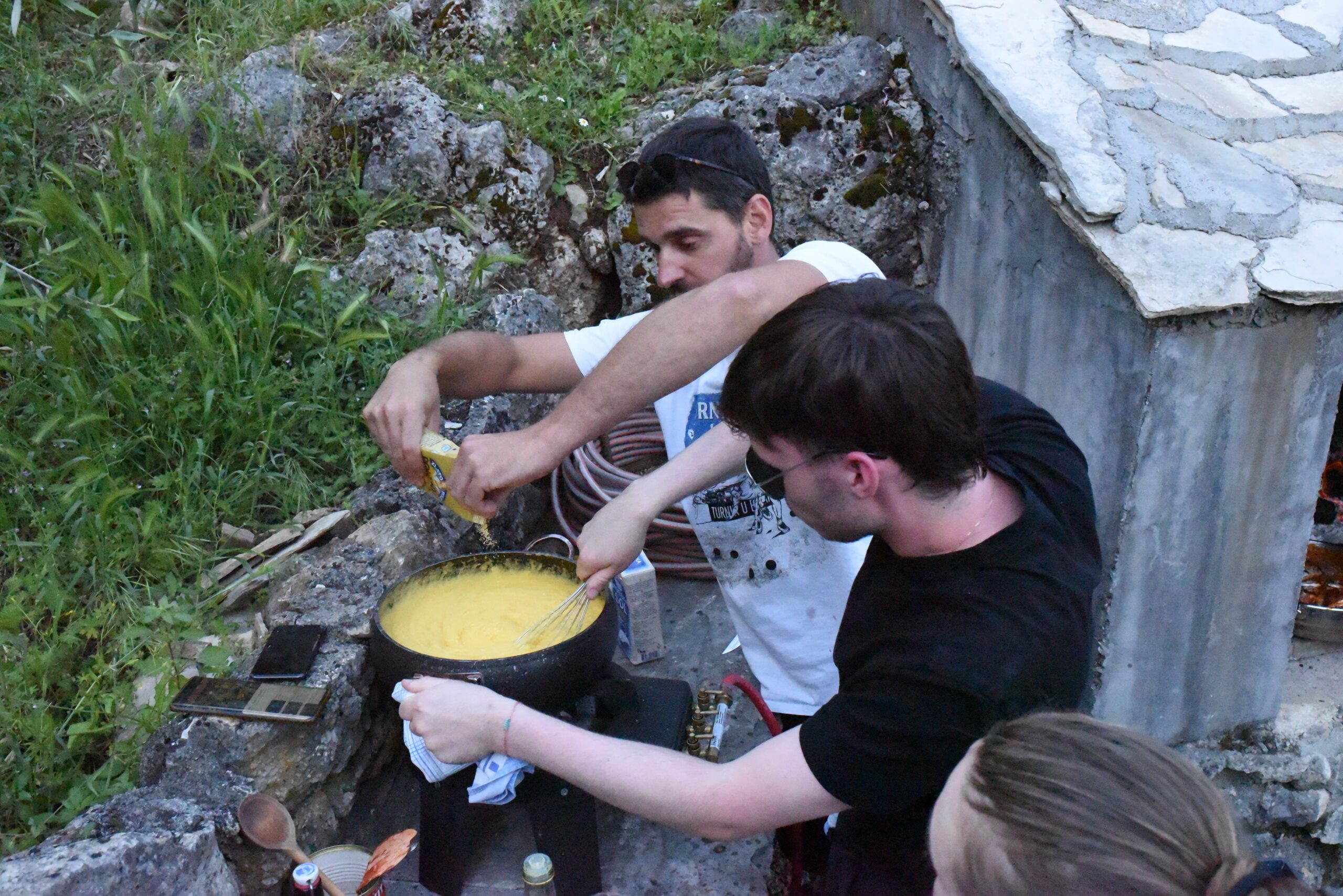 Two students cooking with a pan 
