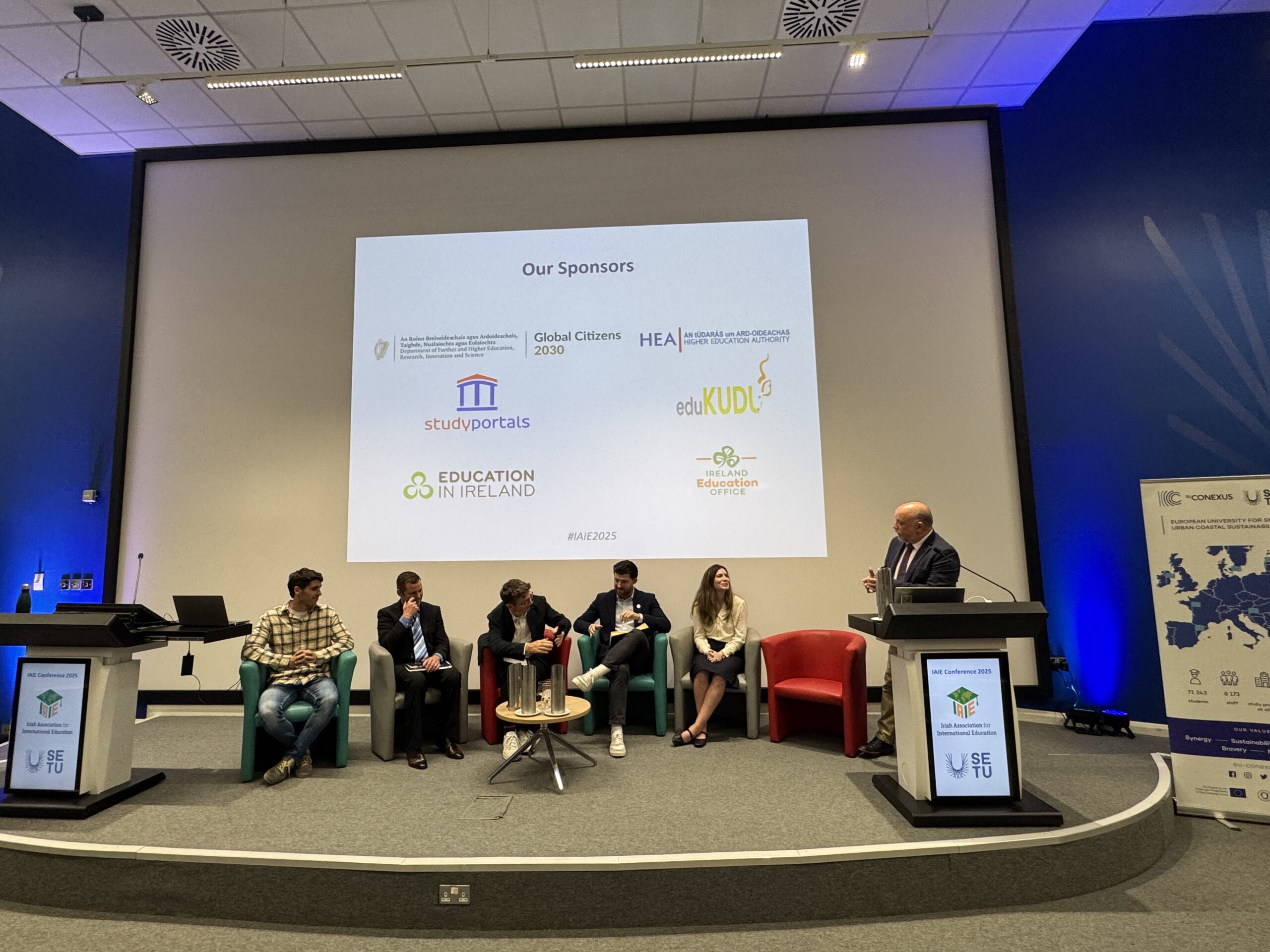 People sitting on a stage as part of panel 