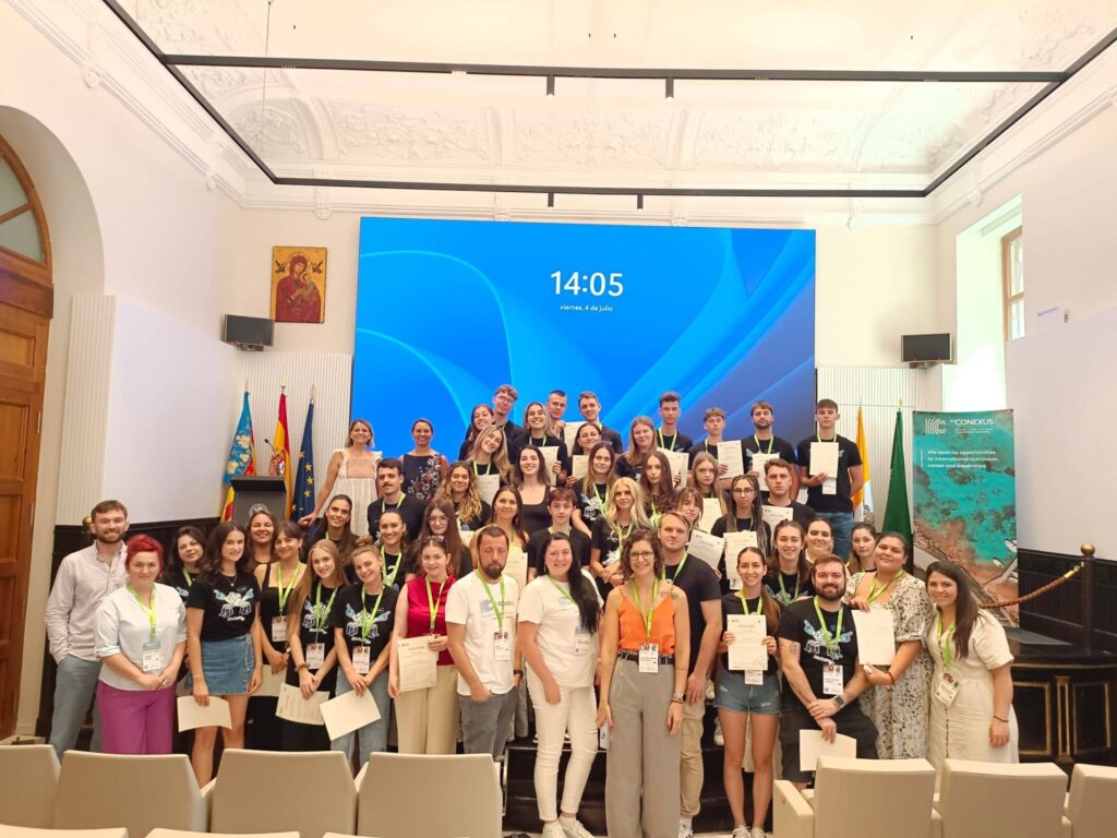A group of students standing in from of a screen with certificates